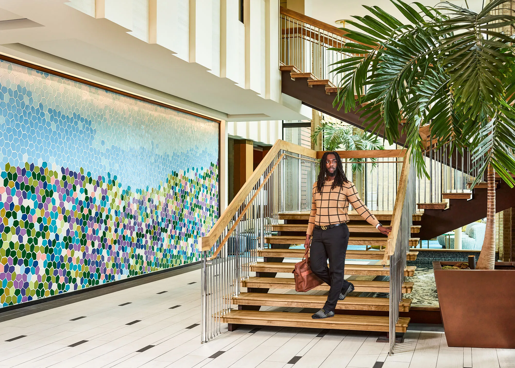 Man standing on staircase in Highland Dallas Lobby
