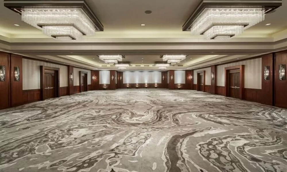 Opus Ballroom empty with wooden and striped wallpaper walls, four large chandeliers and gray and white marble flooring at The Highland Dallas Curio Collection in Dallas , TX