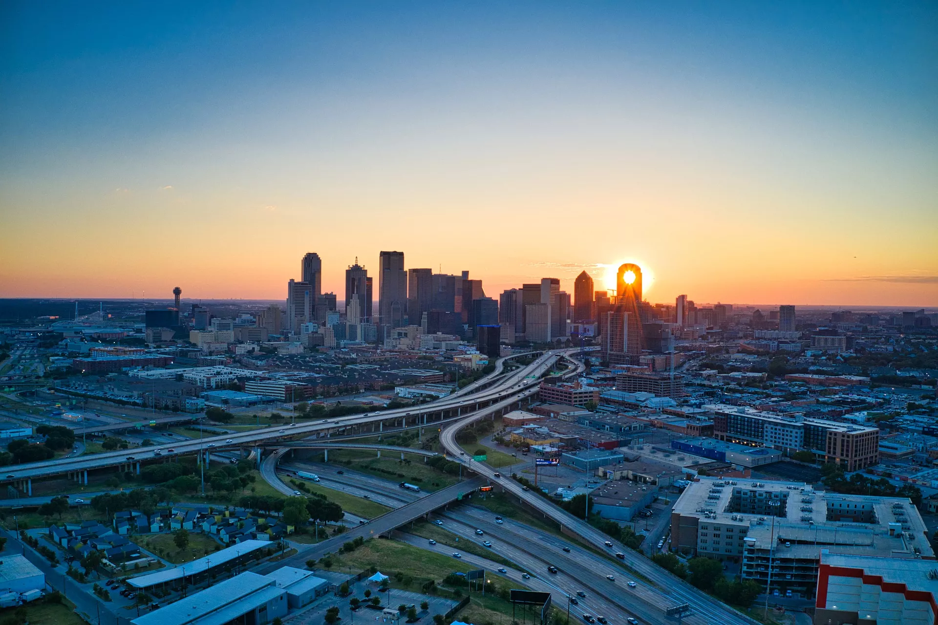 Sunset over the city in Dallas, TX with views of the skyline and highways leading into the city